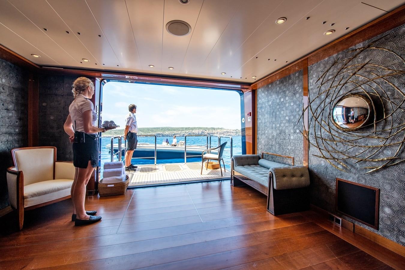 a person standing in a room with a tv and furniture aboard AALTO Yacht for Sale