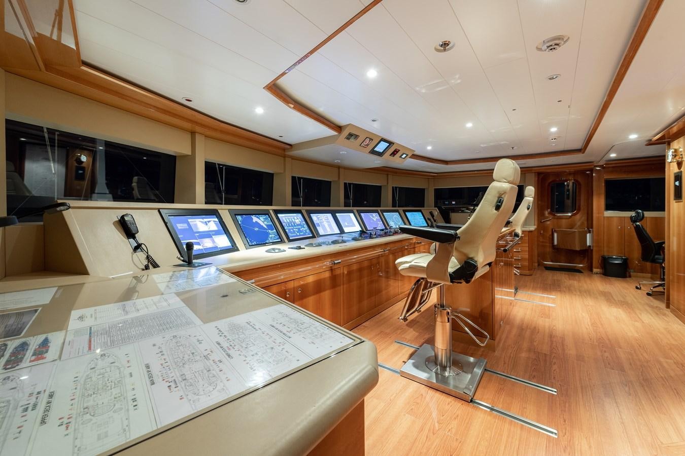 a room with a large white desk and a large screen with a large window and a wood floor aboard AALTO Yacht for Sale