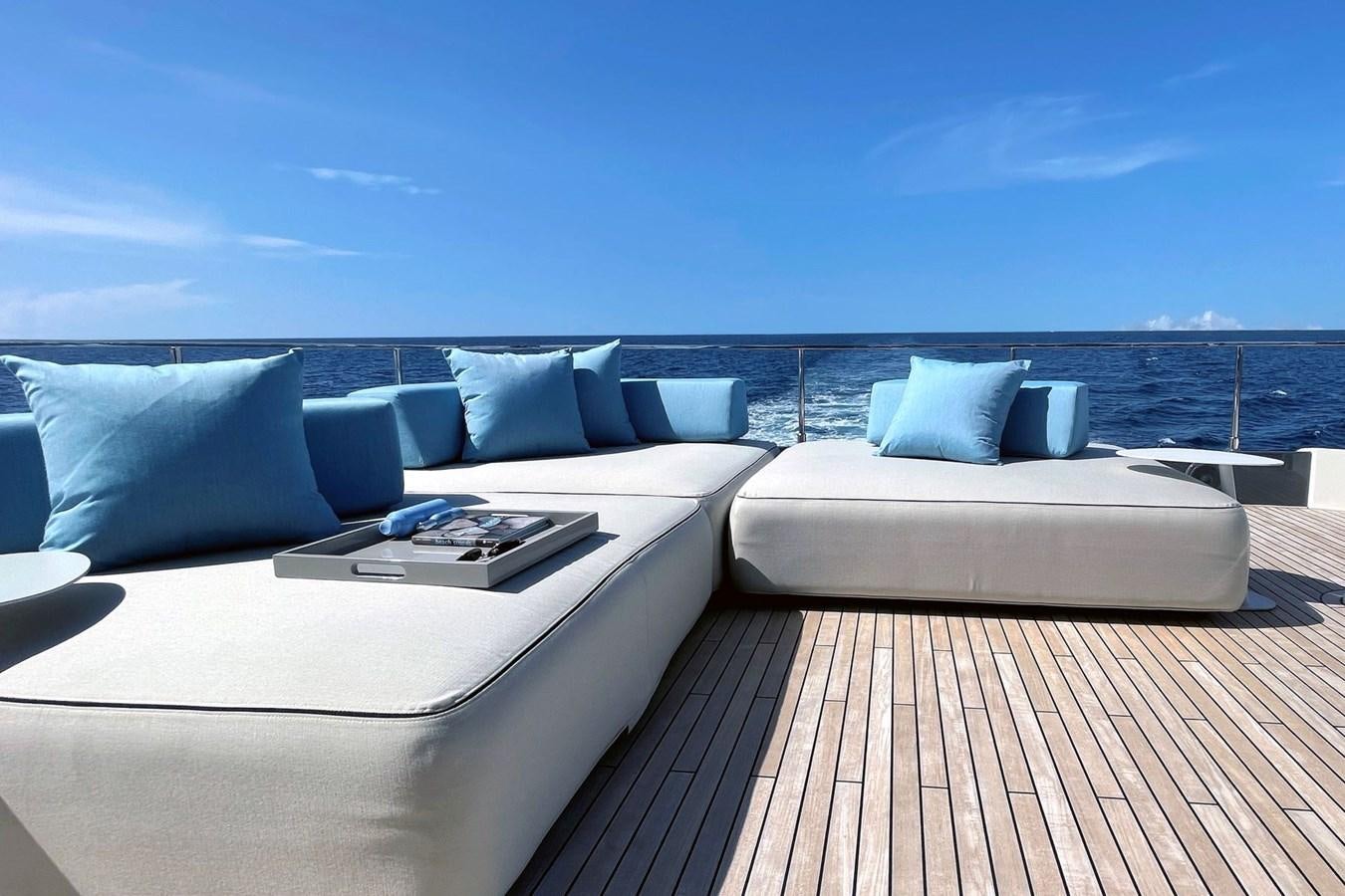 a white couch and a white table on a deck with a view of the ocean aboard FERRETTI YACHTS 920 HT  Yacht for Sale