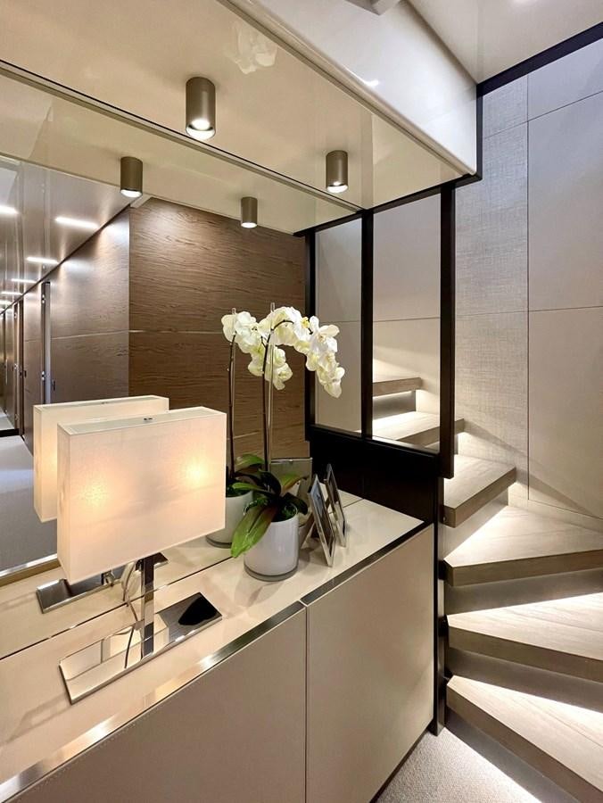 a modern looking staircase with a white vase of flowers on a white stand aboard FERRETTI YACHTS 920 HT  Yacht for Sale
