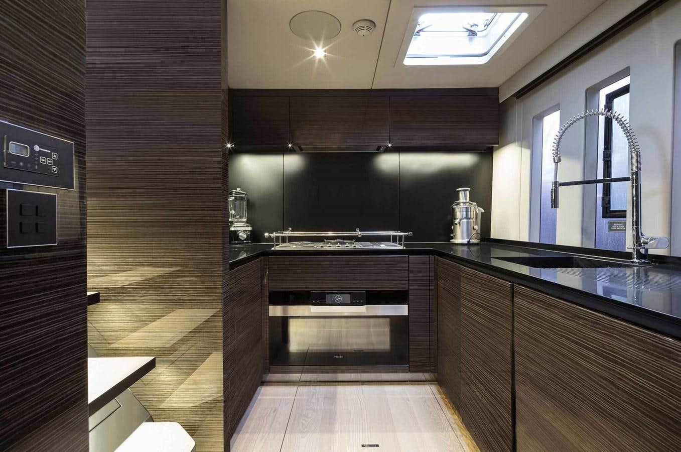 a kitchen with black cabinets aboard ANIMA Yacht for Sale