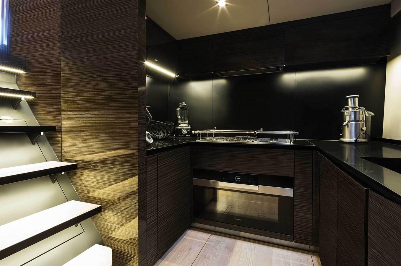 a kitchen with black cabinets aboard ANIMA Yacht for Sale