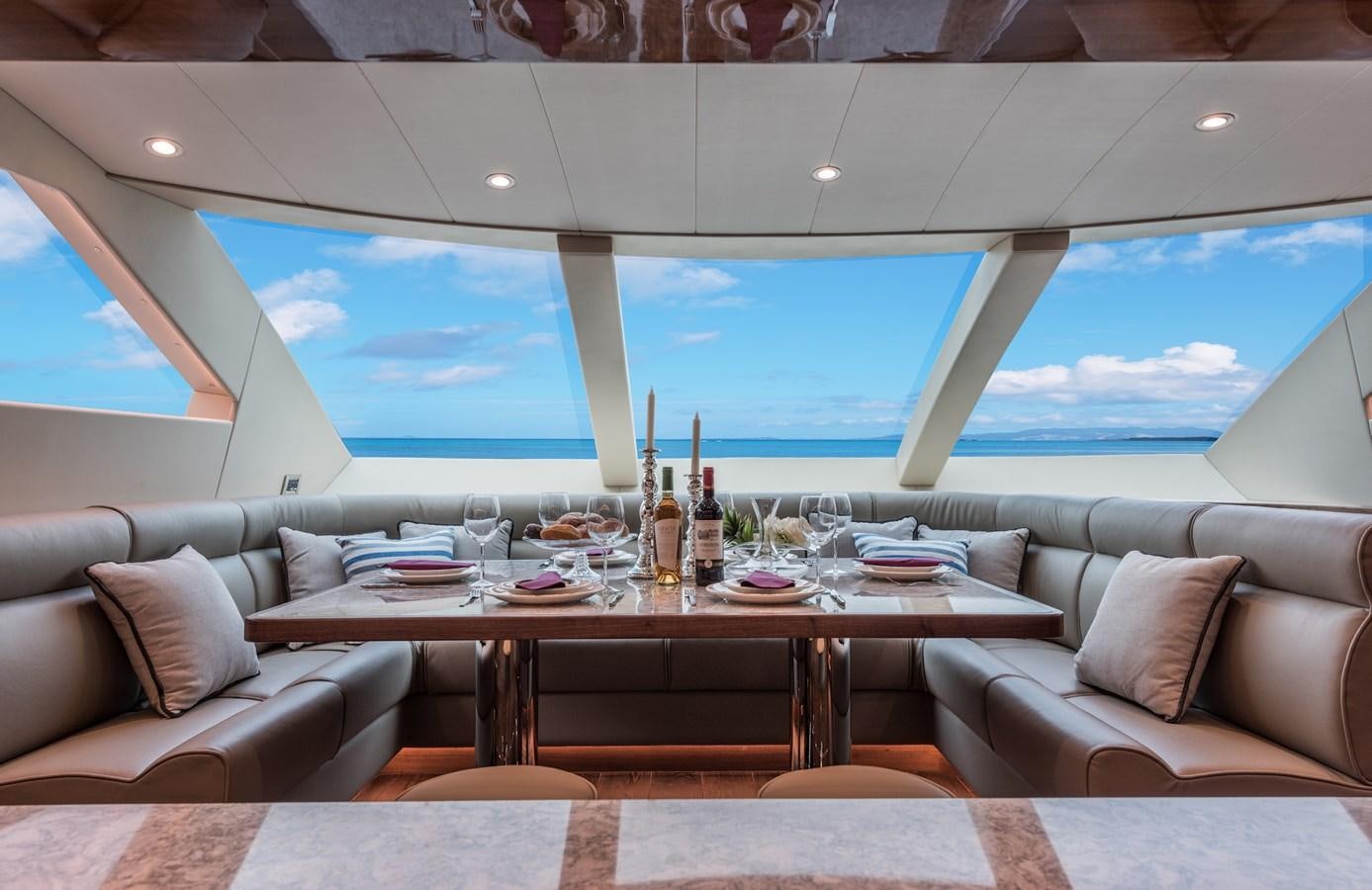 a table with a glass of wine on it aboard HORIZON E100 Yacht for Sale
