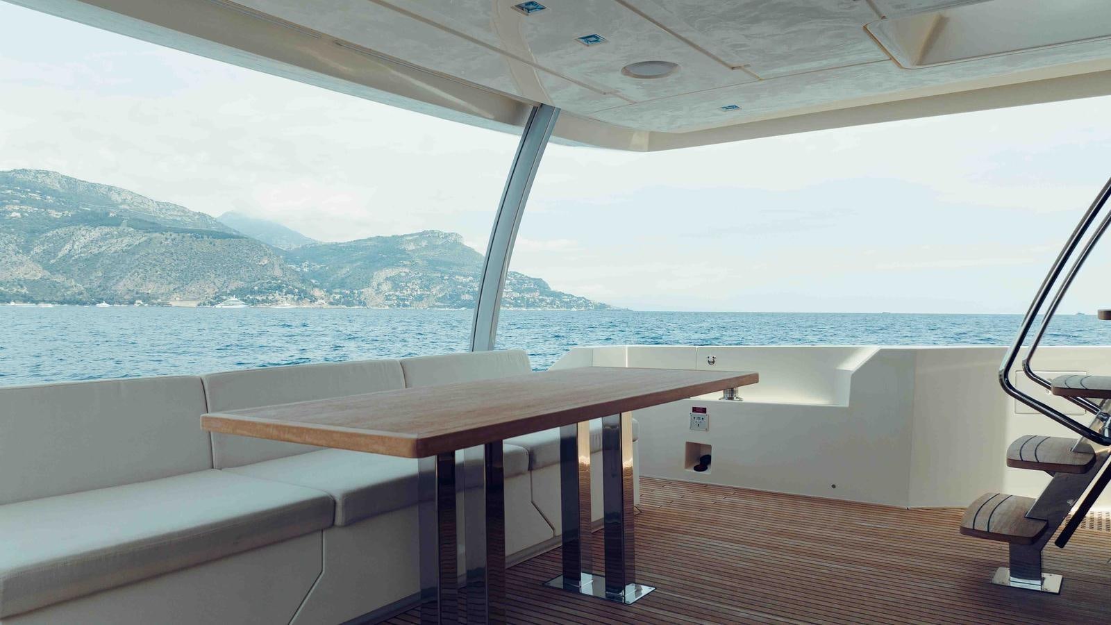 a table on a deck overlooking a body of water aboard FEU D'OR Yacht for Sale