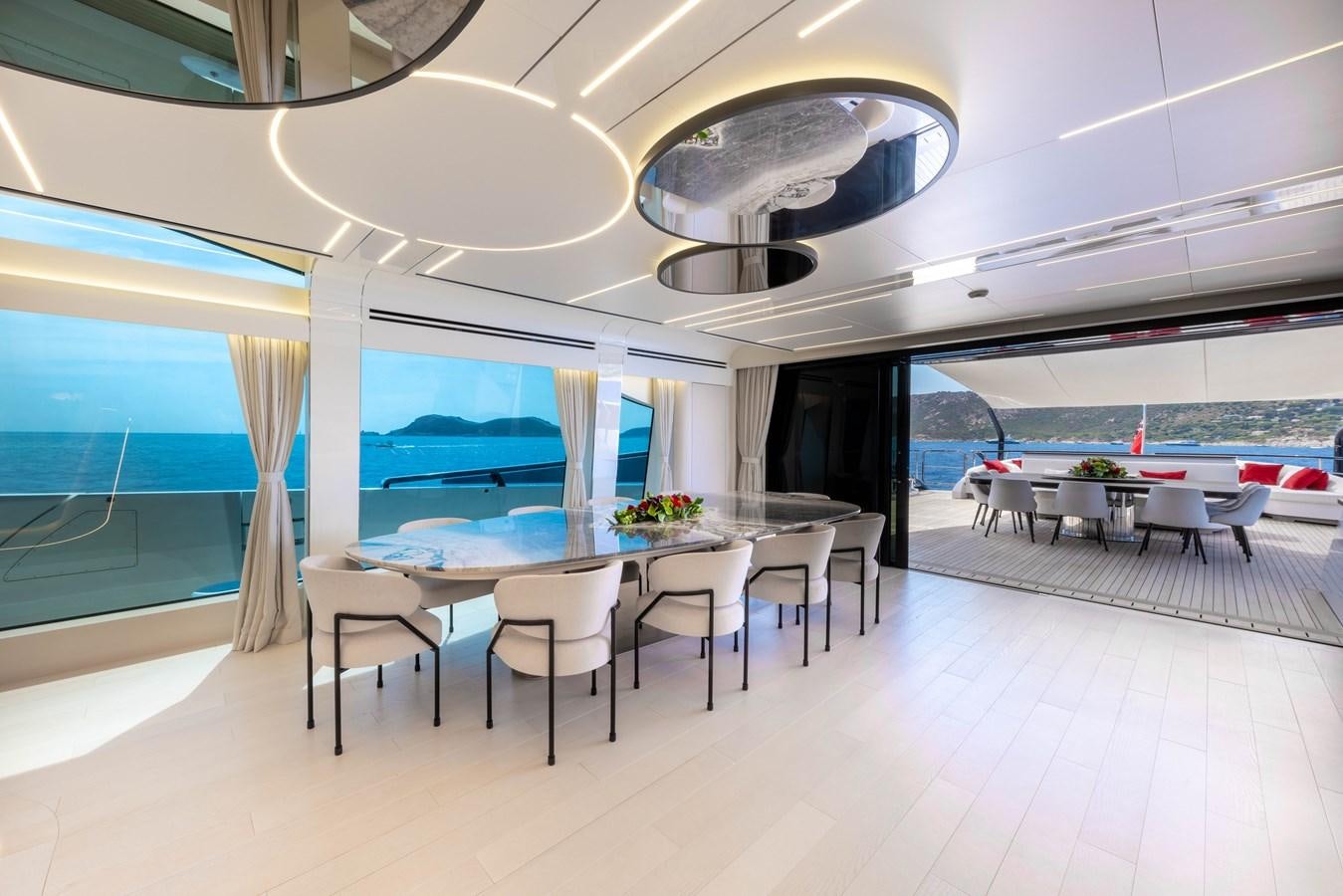 a room with tables and chairs aboard N1 Yacht for Sale
