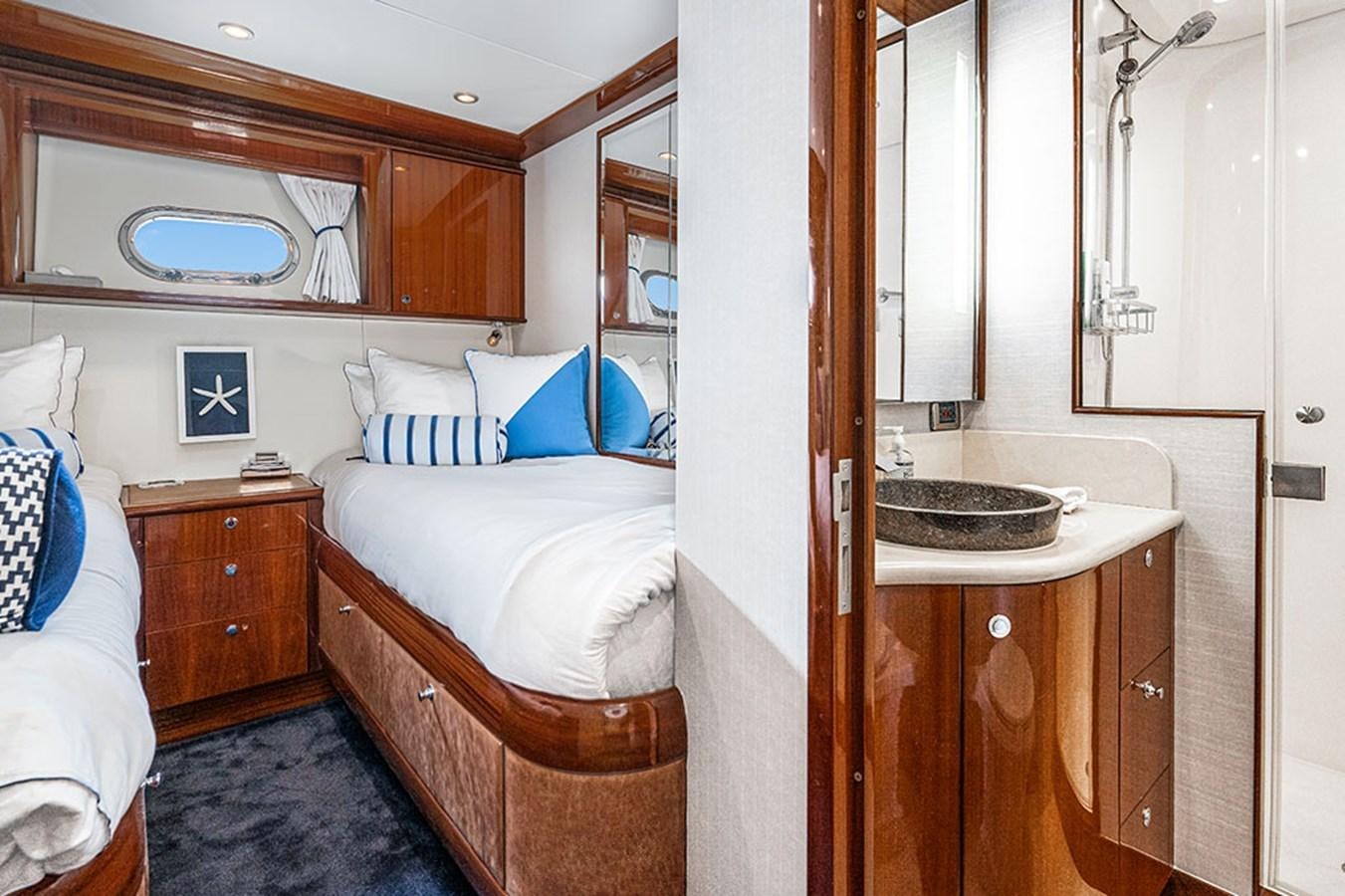 a small bedroom with a bed and a sink aboard WICKED COOL Yacht for Sale