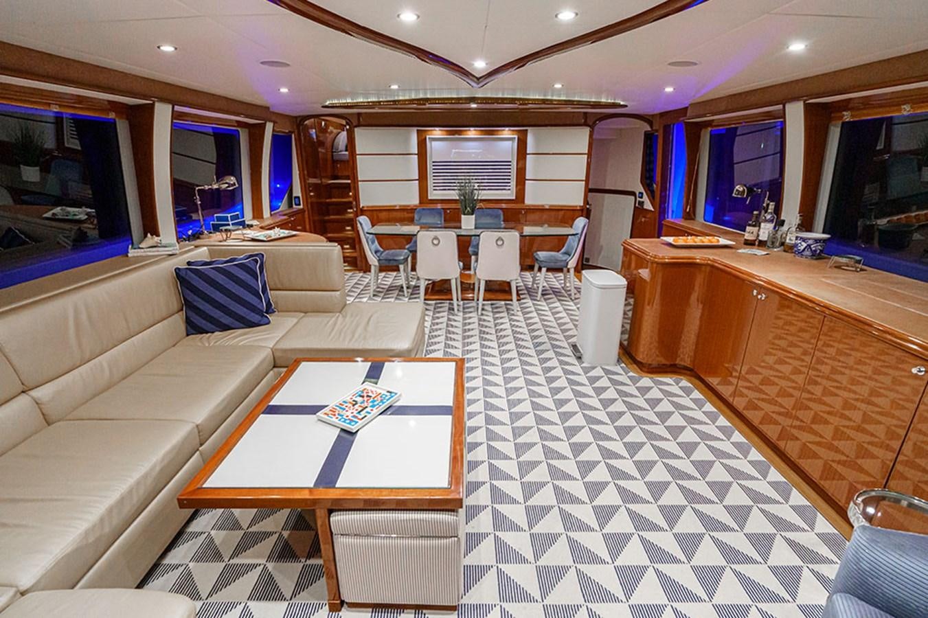 a room with a table chairs and a couch aboard WICKED COOL Yacht for Sale