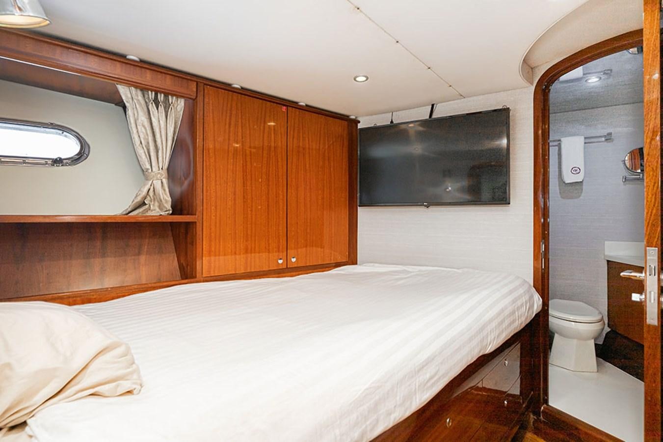 a bedroom with a bed and a mirror aboard WICKED COOL Yacht for Sale
