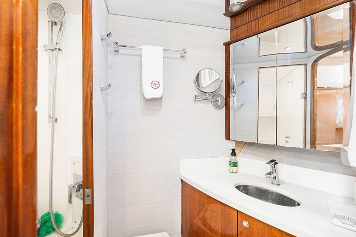 a bathroom with a sink and mirror aboard WICKED COOL Yacht for Sale