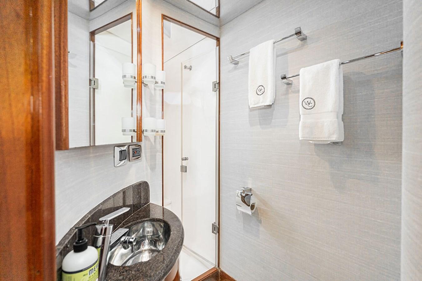 a bathroom with a sink and mirror aboard WICKED COOL Yacht for Sale