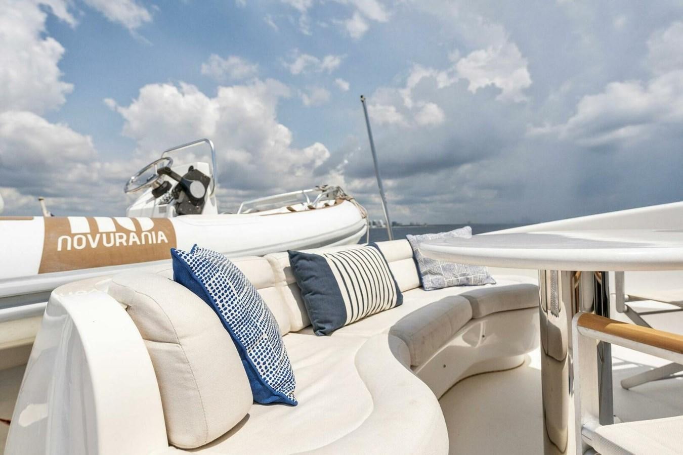 a white bed with white pillows and a white tent with a white sky and clouds aboard NORDLYS Yacht for Sale