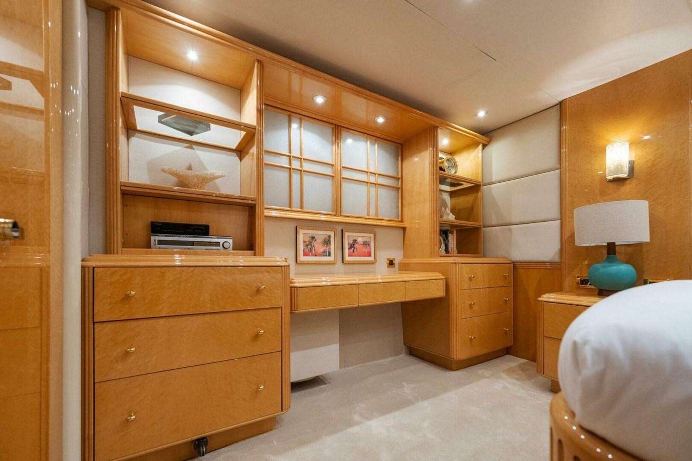a room with a bed and a shelf with books on it aboard NORDLYS Yacht for Sale