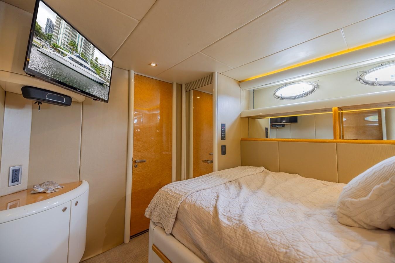 a room with a bed and a television on the wall aboard BOURBON LEGEND Yacht for Sale