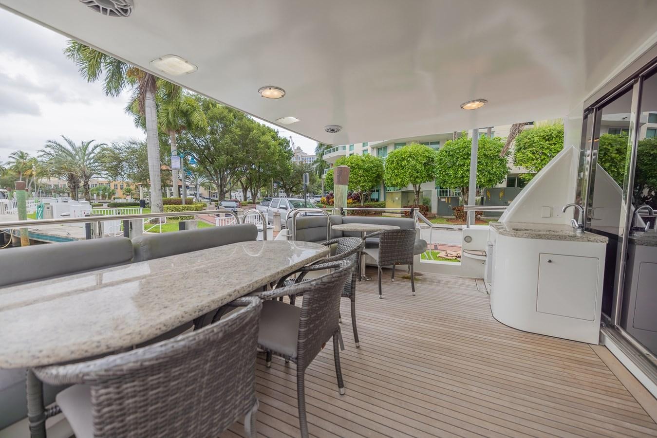 a deck with a table and chairs aboard BOURBON LEGEND Yacht for Sale