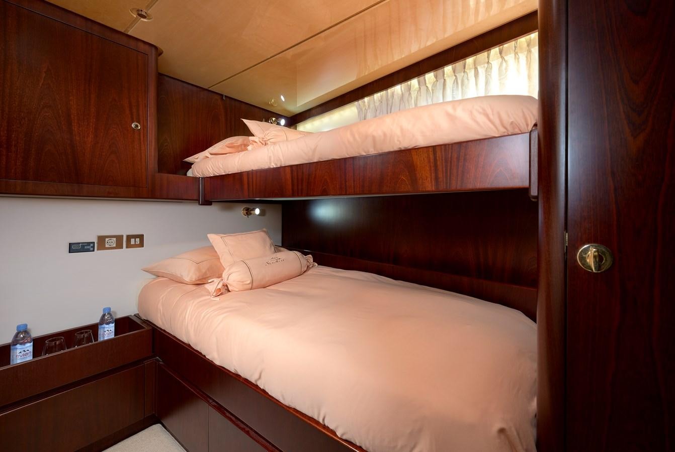 a room with a bed and a wood cabinet aboard LADY SUNSHINE Yacht for Sale