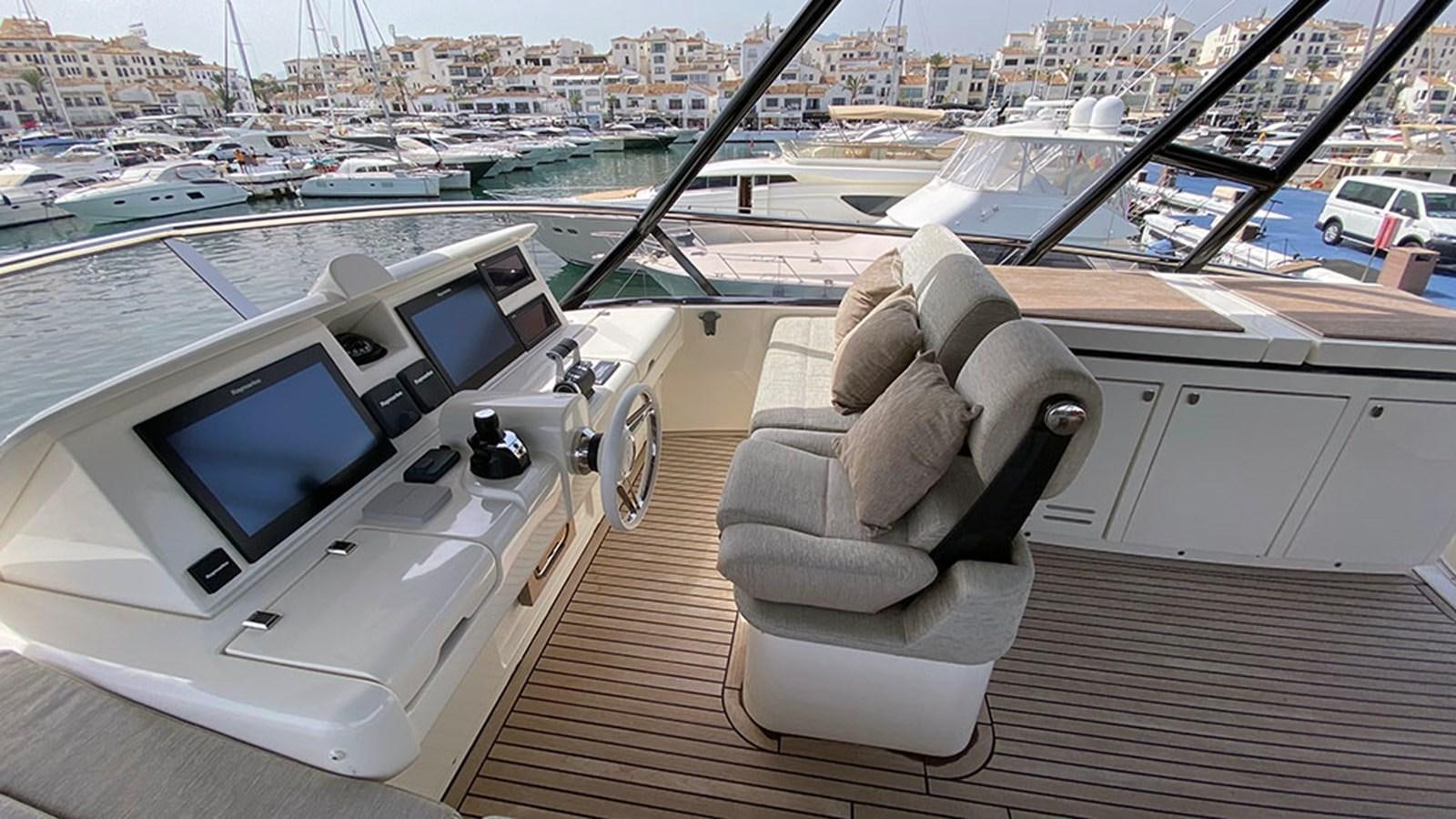 a chair on a deck overlooking a marina aboard CAPPUCCINO Yacht for Sale
