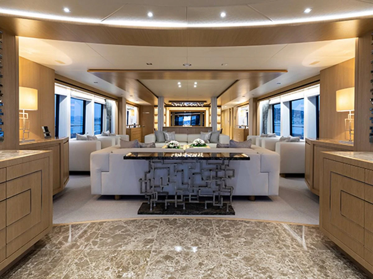 a large living room with a large white sofa and a large table aboard ELYSIUM Yacht for Sale