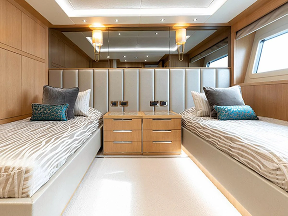 a room with a bed and a dresser aboard ELYSIUM Yacht for Sale