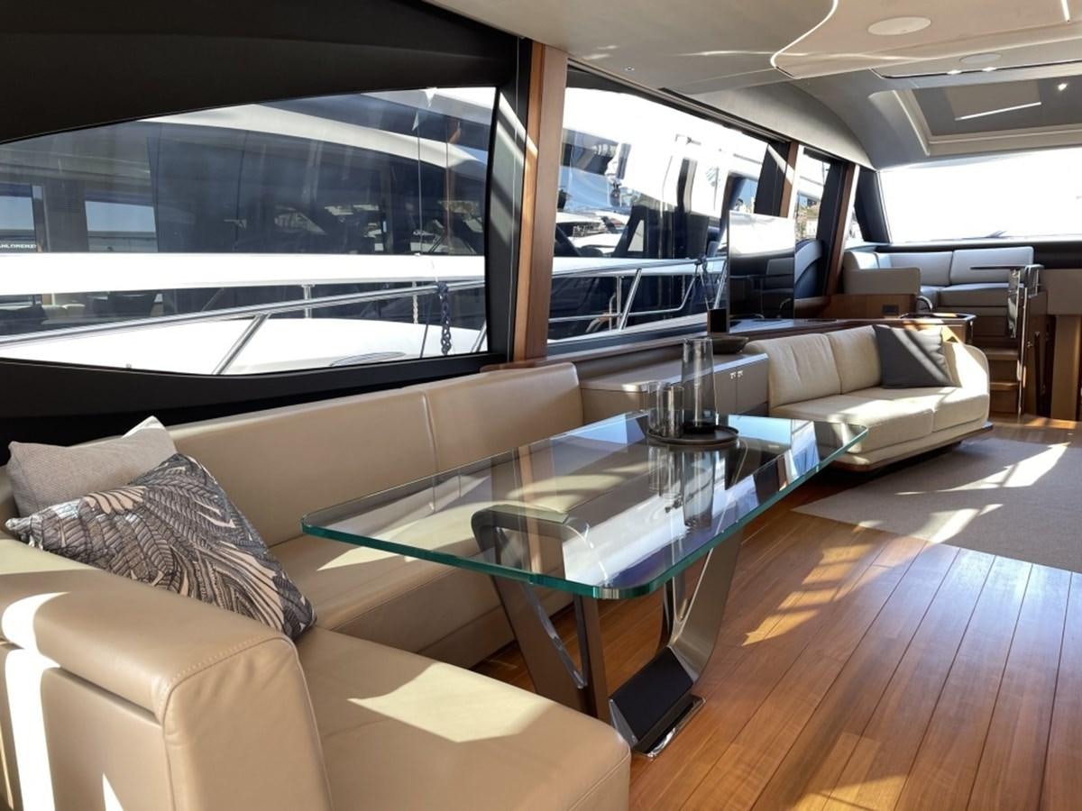 a living room with a large glass table and a large window aboard PRINCESS S78 Yacht for Sale