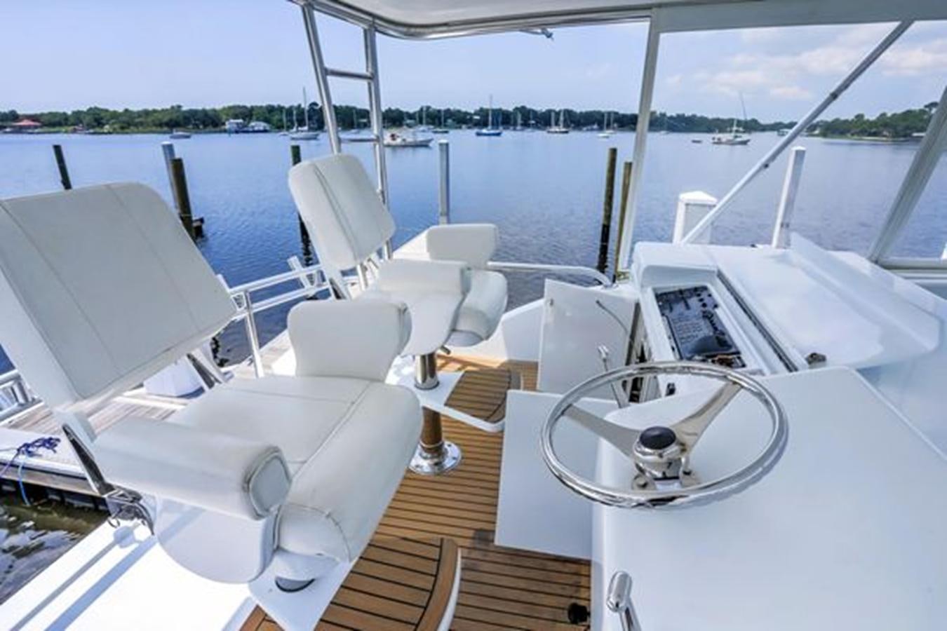a boat with a steering wheel and chairs on it aboard 2007 68 HATTERAS CONVERTIBLE Yacht for Sale