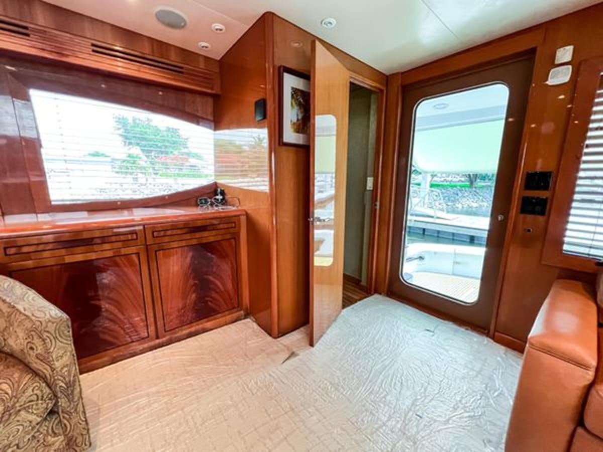 a bedroom with a bed and a window aboard 2007 68 HATTERAS CONVERTIBLE Yacht for Sale