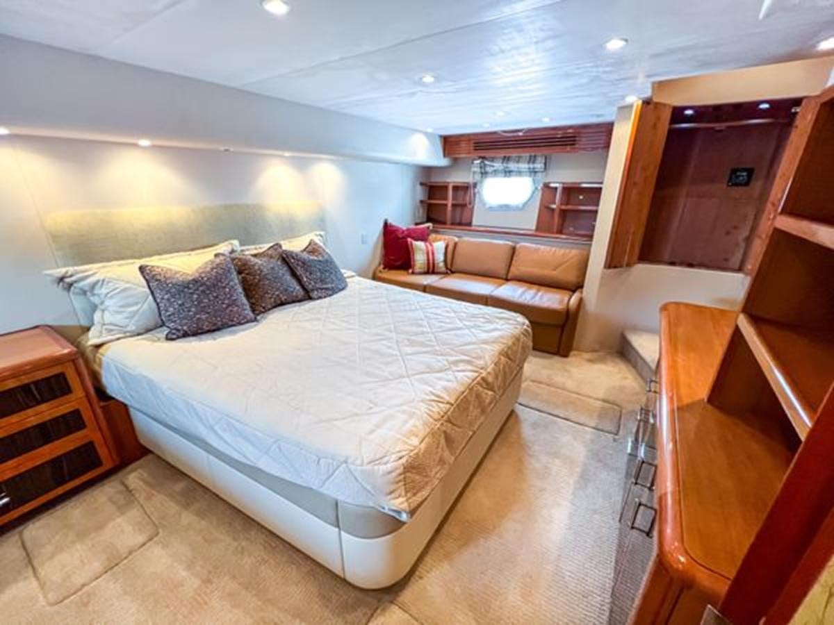 a bedroom with a bed and a couch aboard 2007 68 HATTERAS CONVERTIBLE Yacht for Sale