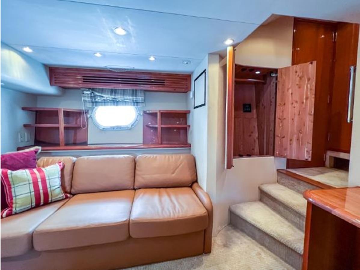 a living room with a couch and a table aboard 2007 68 HATTERAS CONVERTIBLE Yacht for Sale