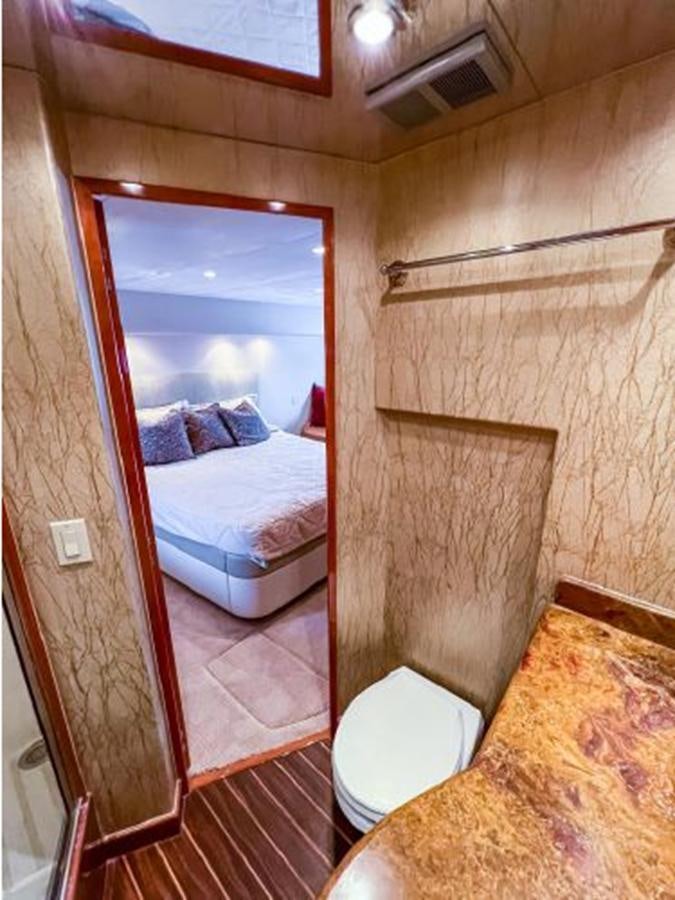 a bedroom with a large mirror aboard 2007 68 HATTERAS CONVERTIBLE Yacht for Sale