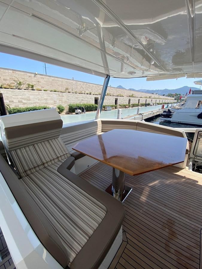 a deck with a table and chairs aboard GALEON 640 Yacht for Sale