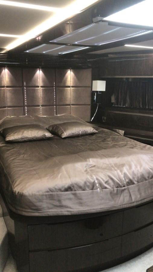 a bed with a white sheet and a black wall aboard GALEON 640 Yacht for Sale