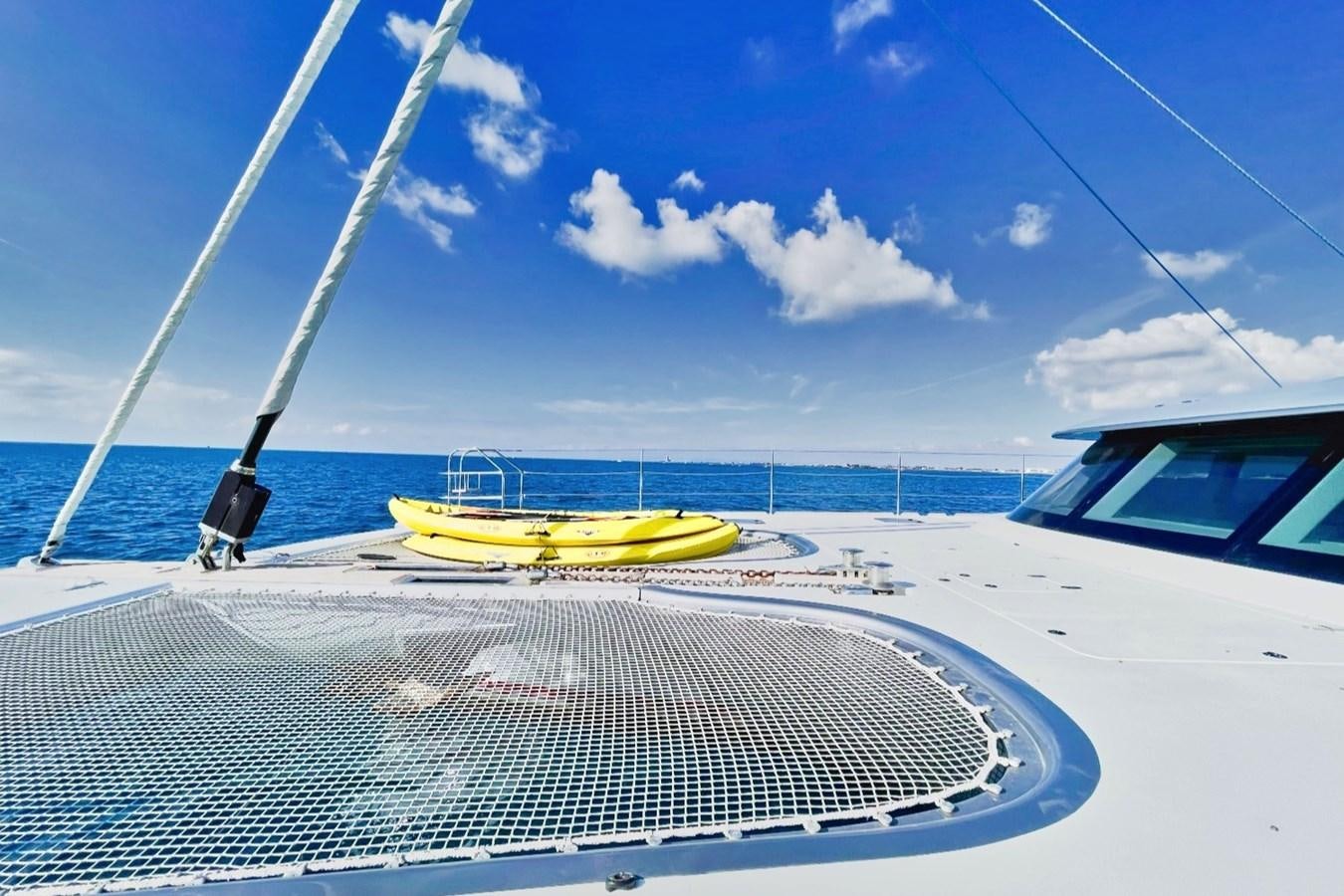 a yellow surfboard on a boat aboard ALKIMIA Yacht for Sale