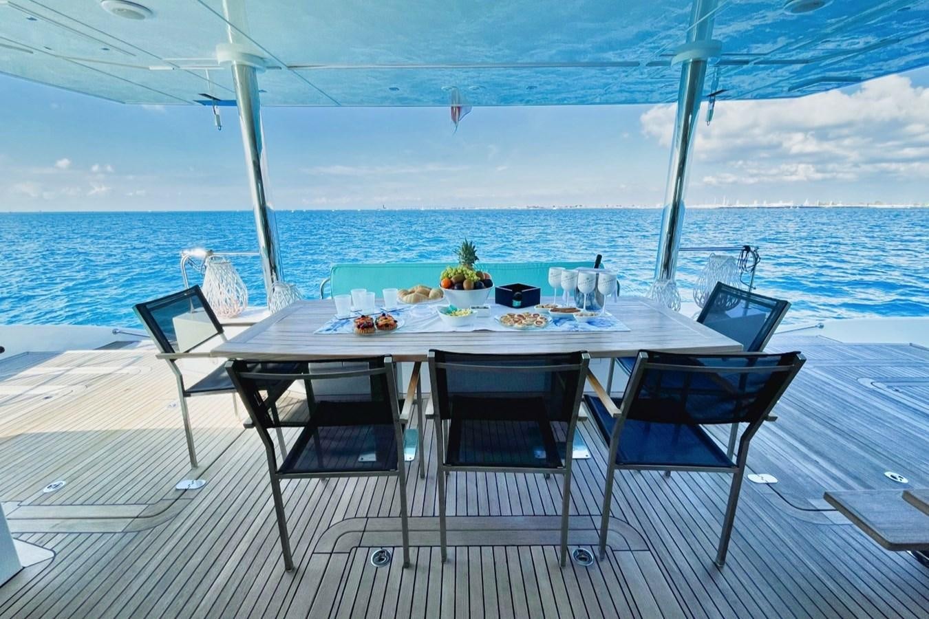 a table on a deck overlooking the ocean aboard ALKIMIA Yacht for Sale