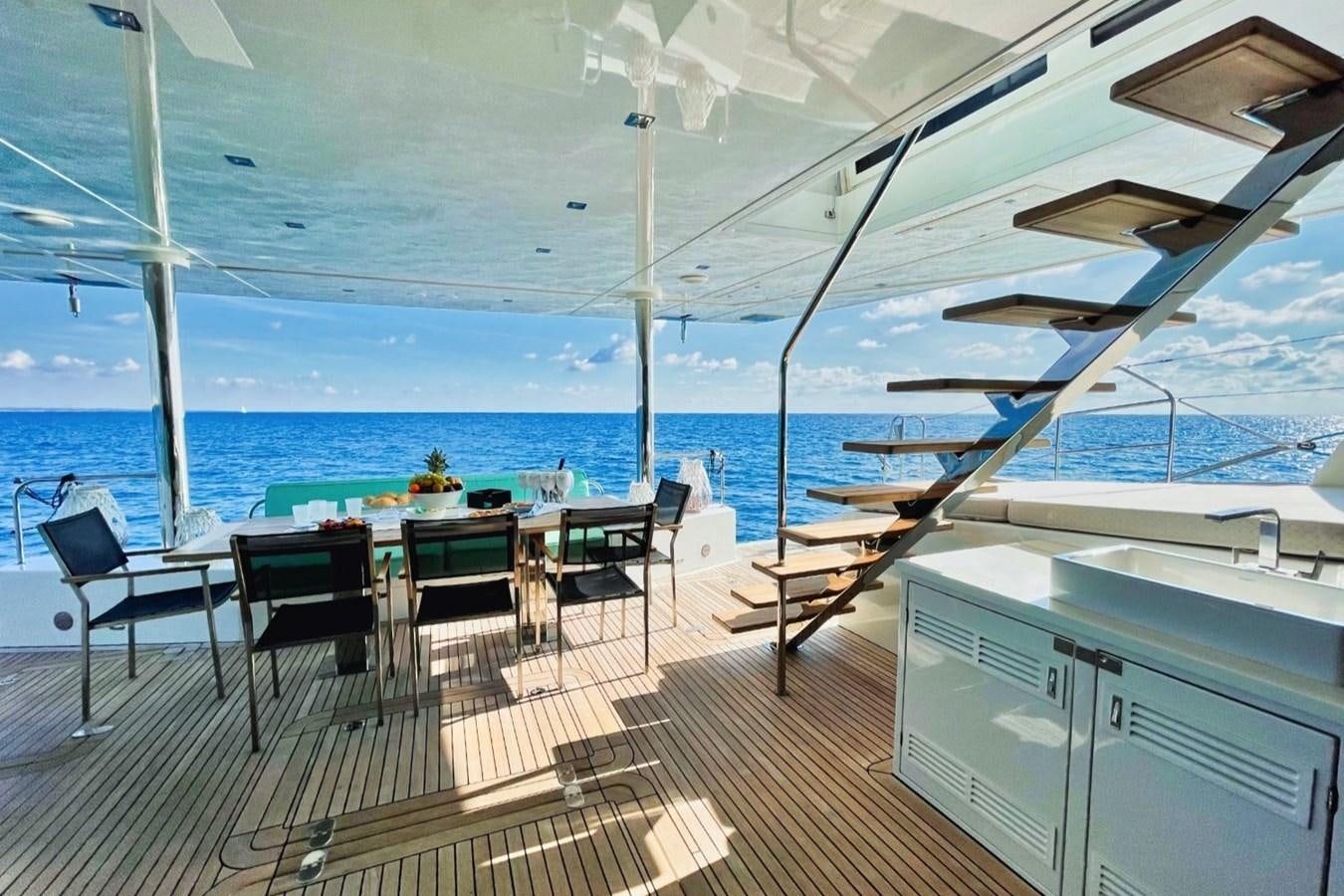 a deck with a table and chairs on it aboard ALKIMIA Yacht for Sale