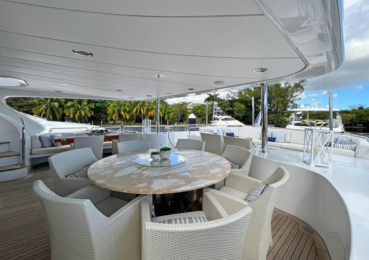 a large outdoor table with chairs and a large white tent aboard FORTIS Yacht for Sale