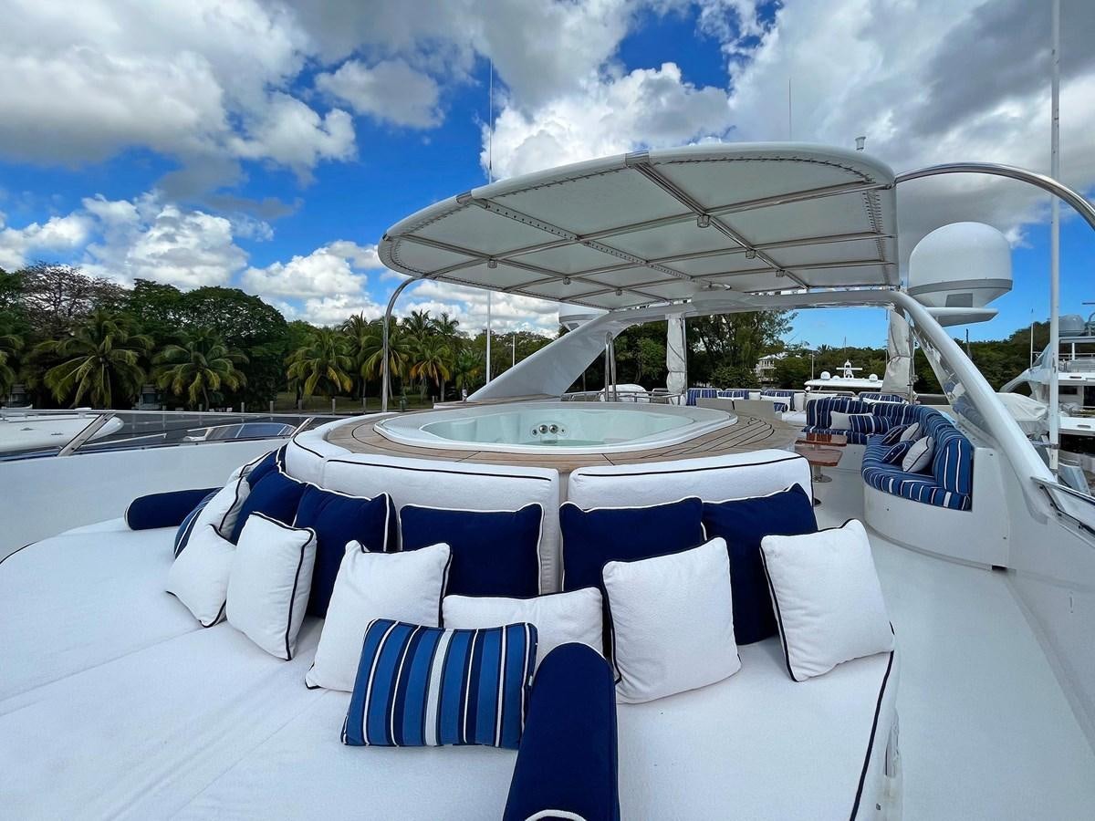 a lounge area with a large white lounge chair and a large white umbrella aboard FORTIS Yacht for Sale