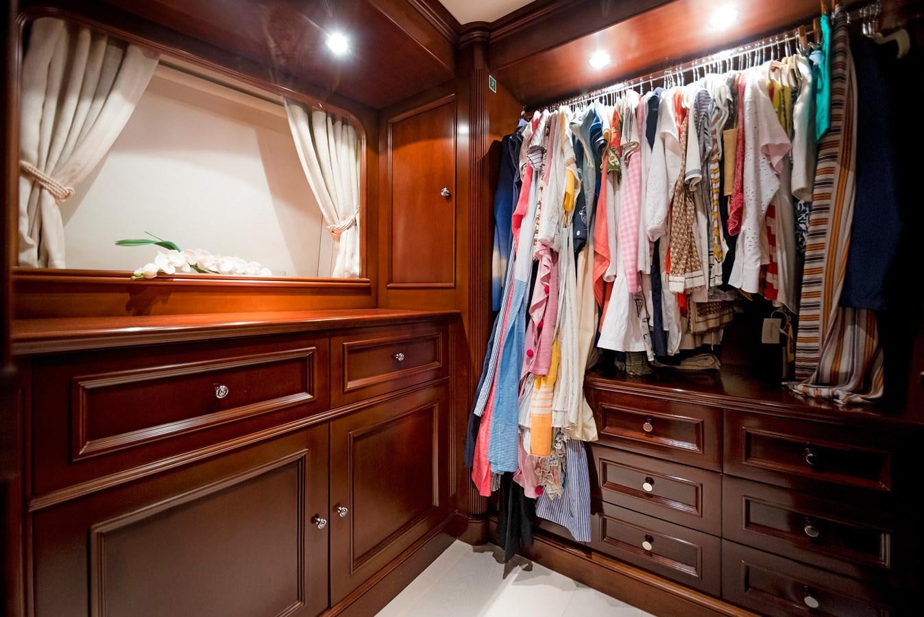 a closet with clothes on the wall aboard FORTIS Yacht for Sale