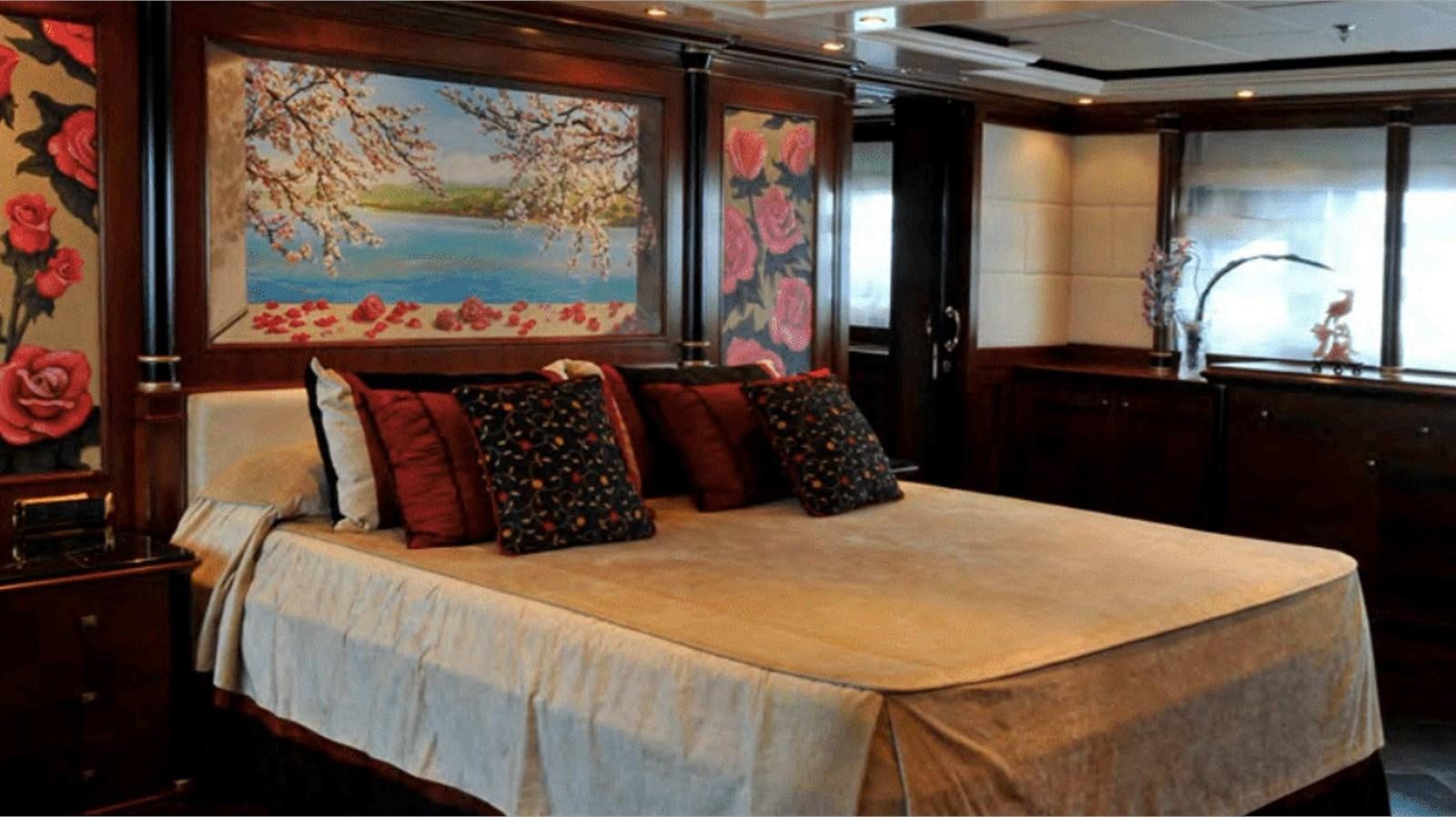 a bed with a painting on the wall aboard MOZA Yacht for Sale