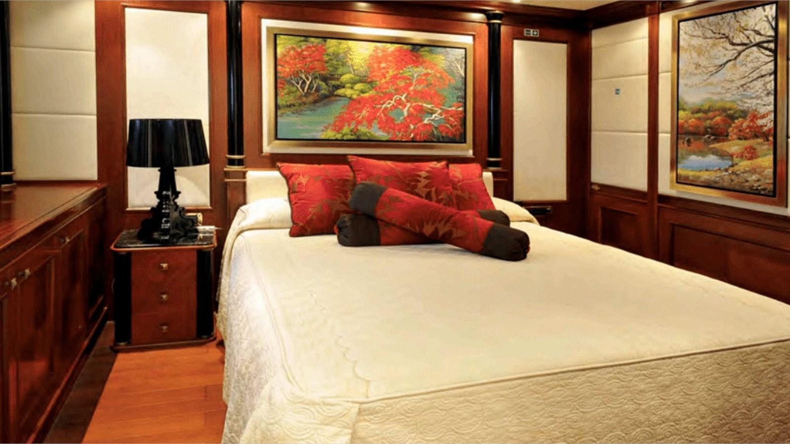 a bed with a red pillow aboard MOZA Yacht for Sale