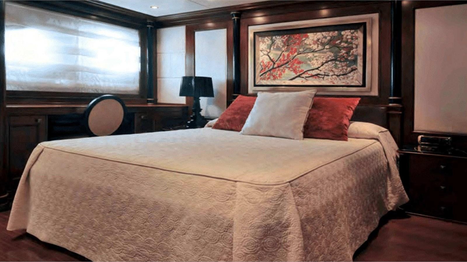 a large bed with red pillows aboard MOZA Yacht for Sale