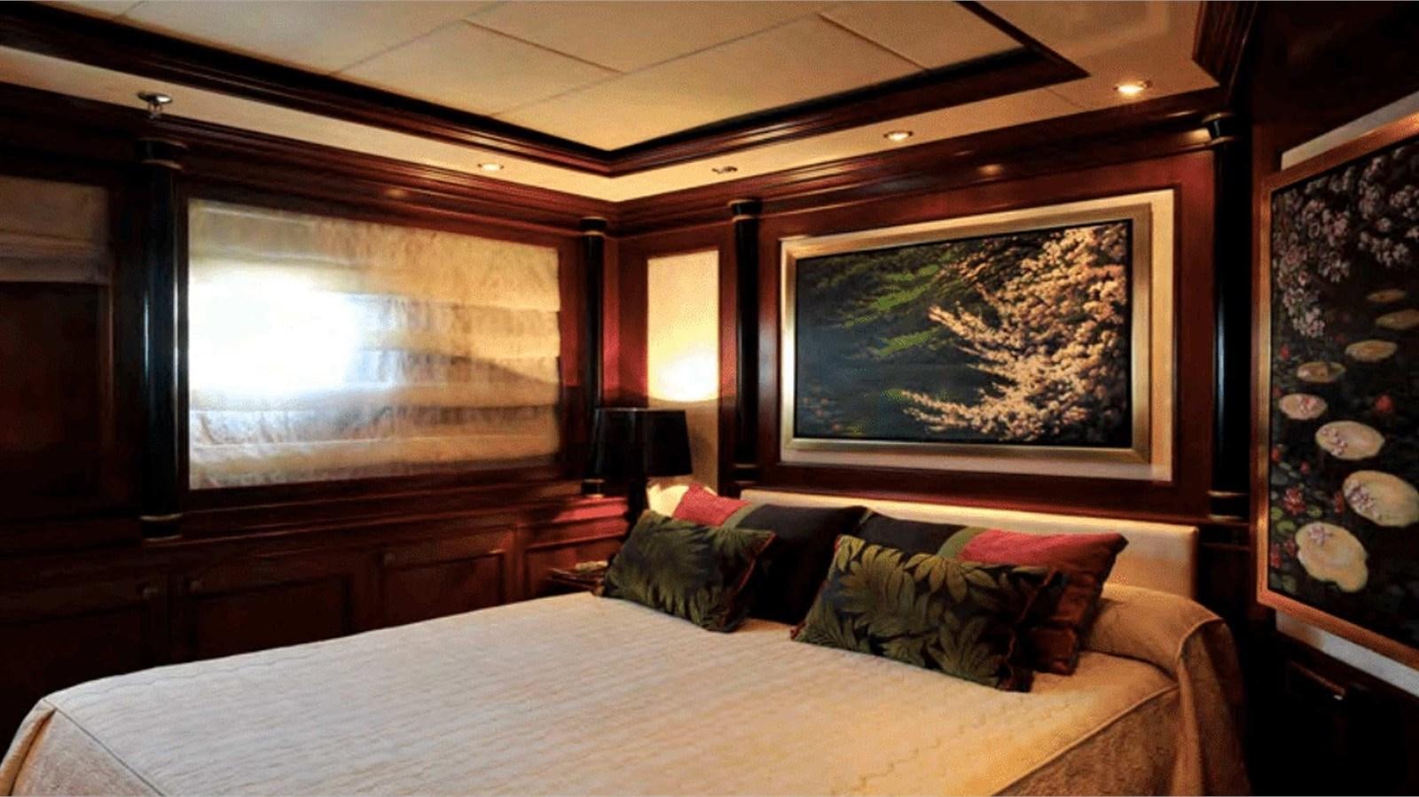 a bed with a painting on the wall aboard MOZA Yacht for Sale