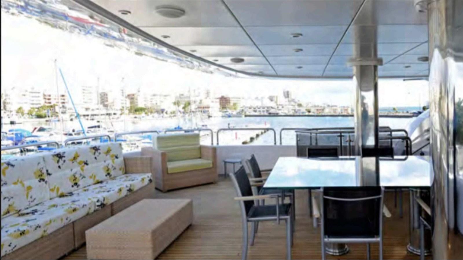 a room with a table chairs and a couch aboard MOZA Yacht for Sale