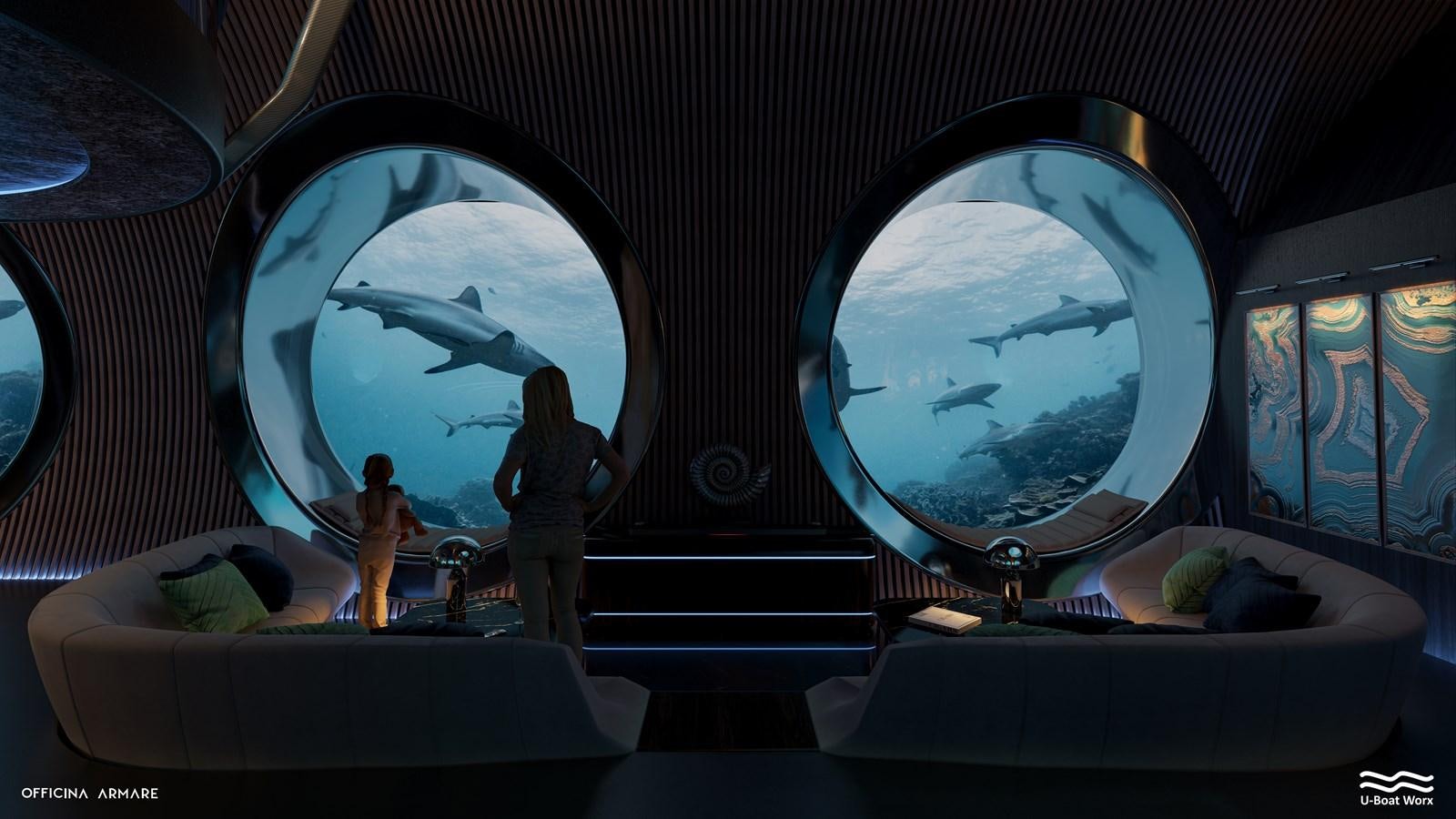 a person standing in front of a large aquarium with fish and a large fish tank aboard NAUTILUS Yacht for Sale