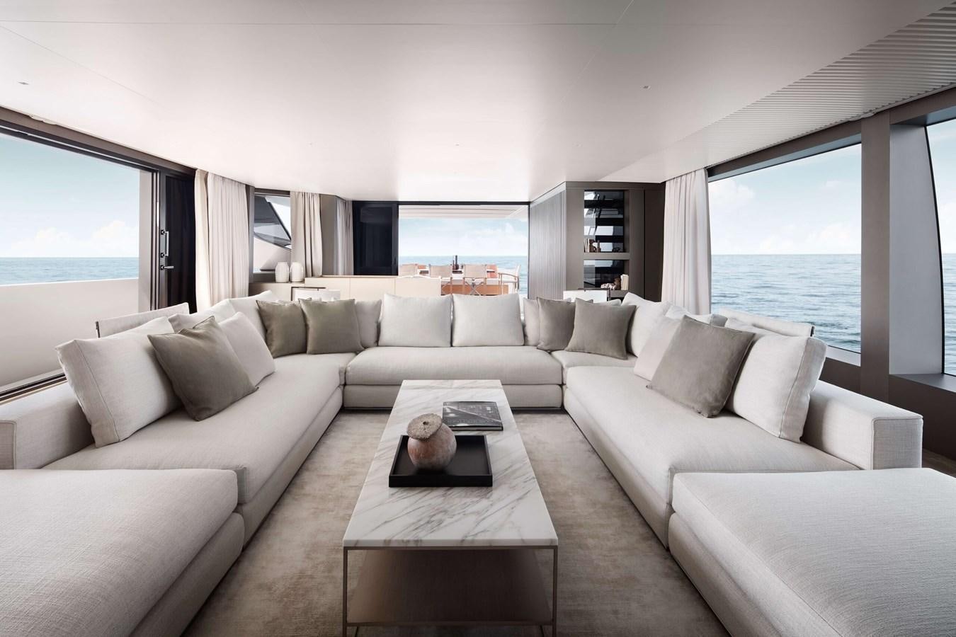 a living room with a large white sofa and a large window aboard COOL Yacht for Sale
