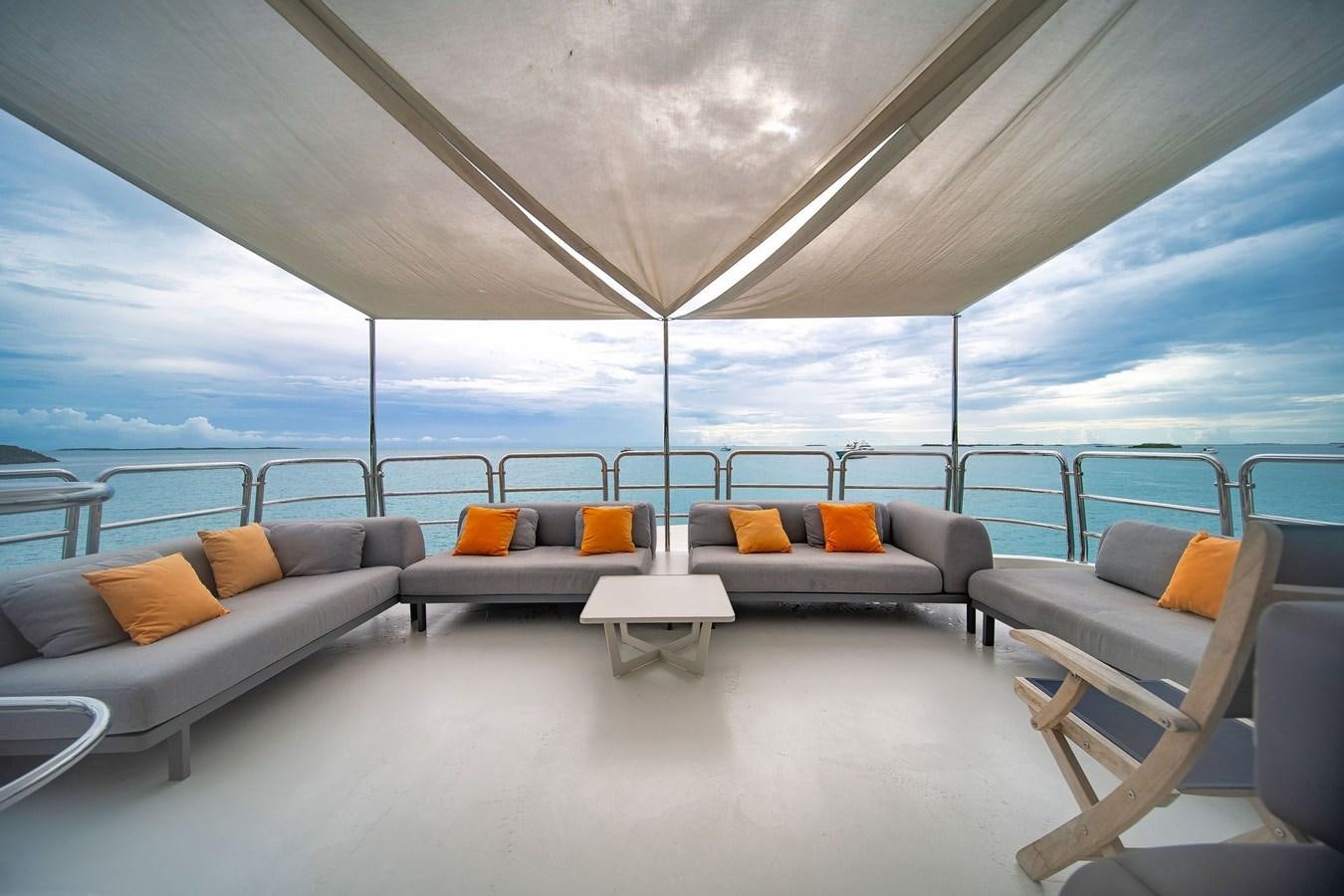 a room with a couch and a table and a large window aboard PAPAITO Yacht for Sale