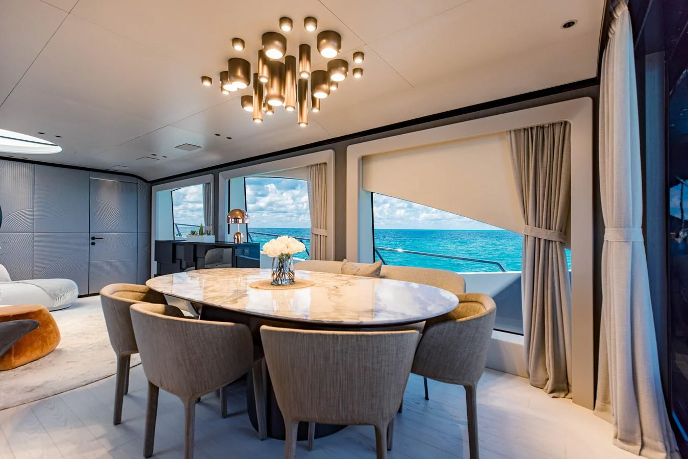 a dining table with chairs and a large window aboard OFFLINE Yacht for Sale
