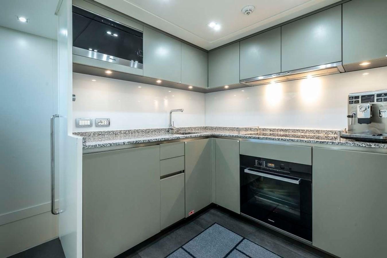 a kitchen with a stove and cabinets aboard 2011 SANLORENZO SD92 FLYBRIDGE Yacht for Sale