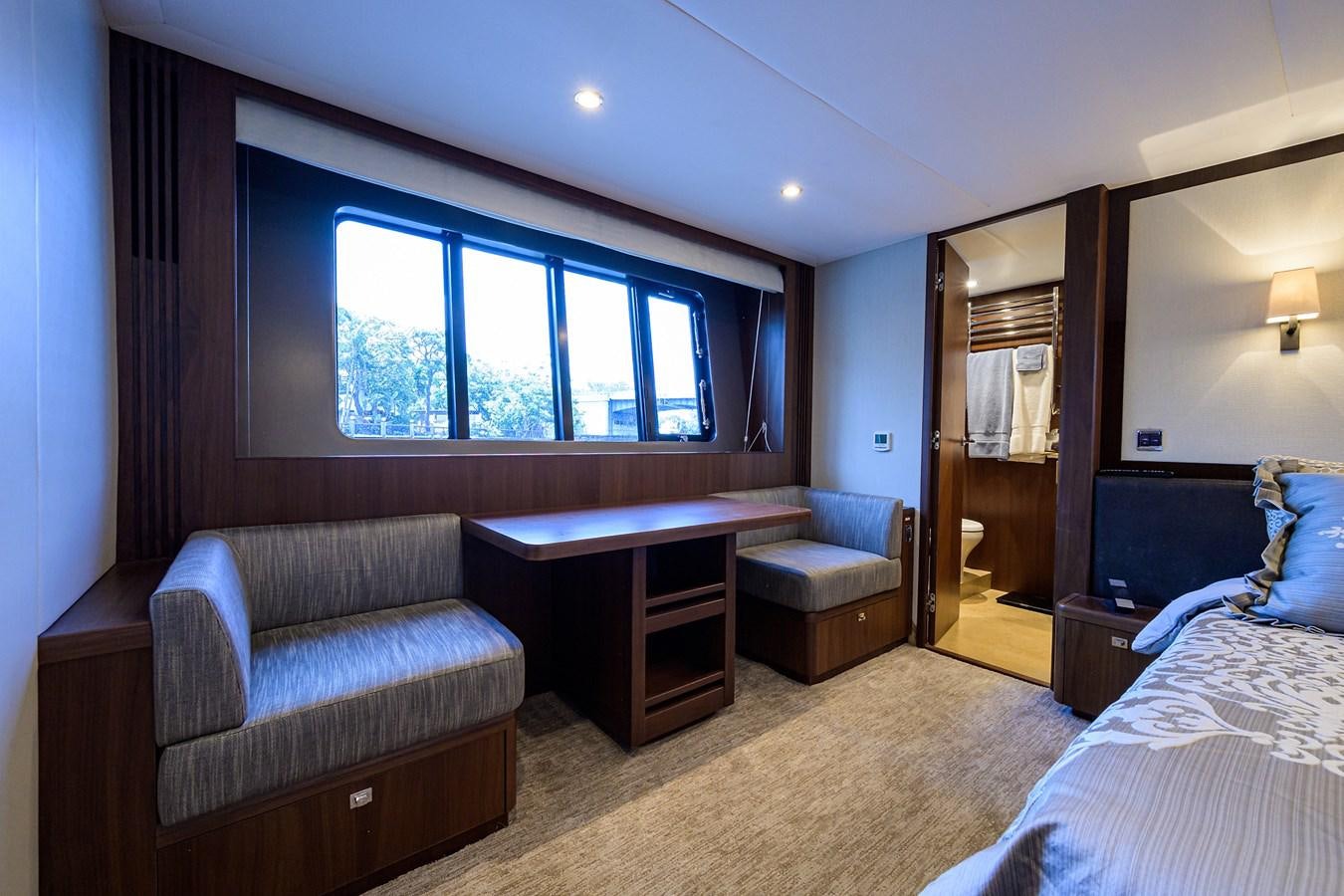 a bedroom with a bed and a desk aboard FREUDIAN SLIP Yacht for Sale