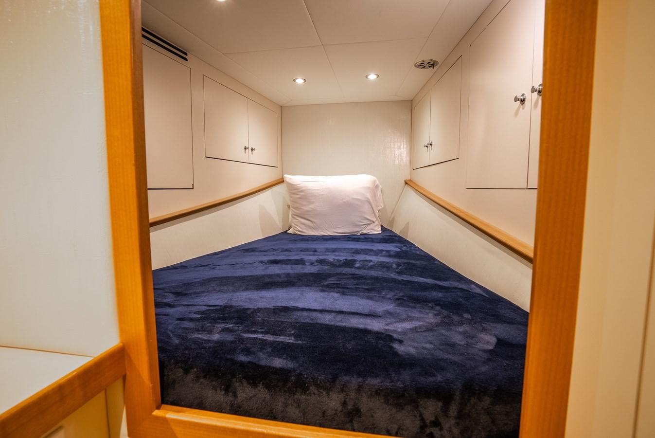 a bed with a blue comforter aboard GATO BLANCO Yacht for Sale