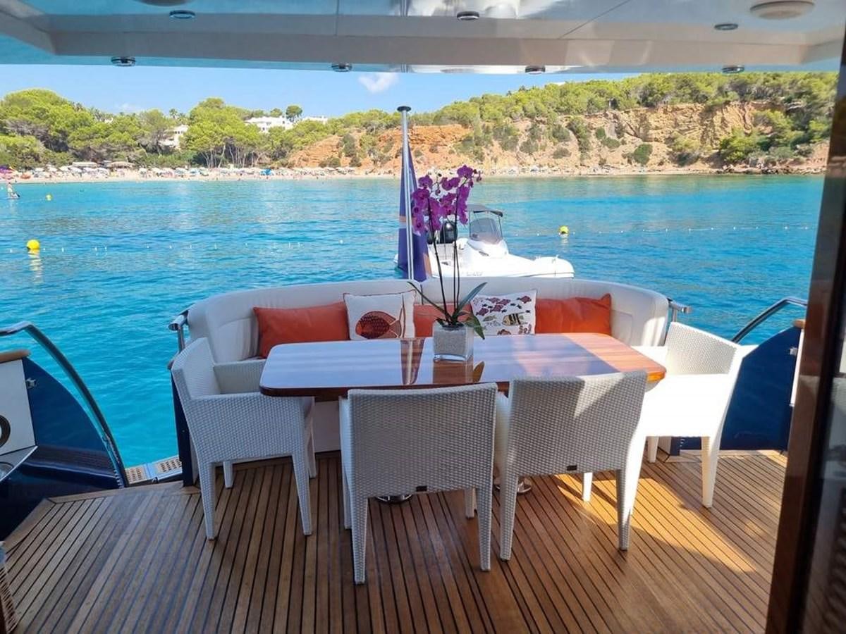 a table set for a meal on a deck overlooking a body of water aboard PLEIADES Yacht for Sale