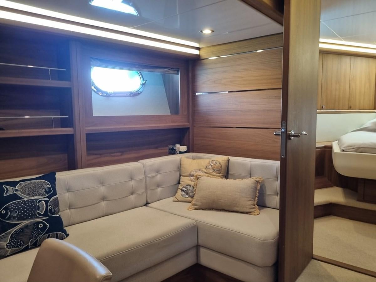 a living room with a couch and a window aboard PLEIADES Yacht for Sale